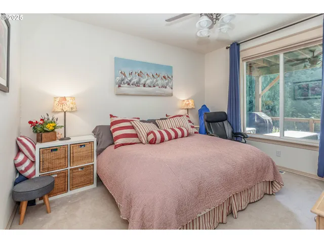 a bedroom with a bed a dresser next to a window