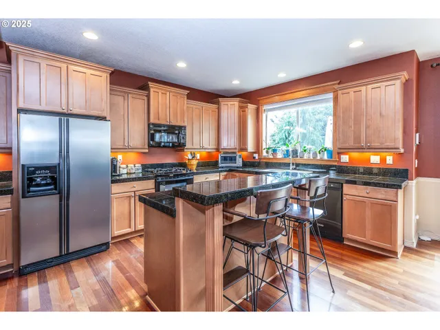 a kitchen with stainless steel appliances granite countertop counter space a sink and a refrigerator