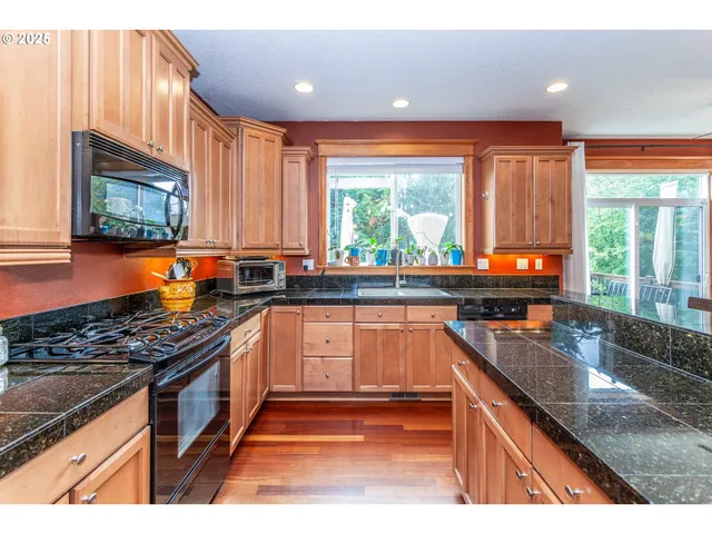 a kitchen with stainless steel appliances granite countertop a stove a sink and a microwave