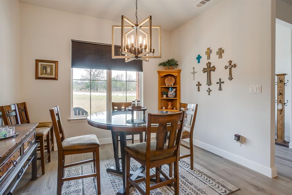 1040 Rose Court Nemo, TX 76070 - Photo 18 of 40 a view of a dining room with furniture a chandelier and wooden floor