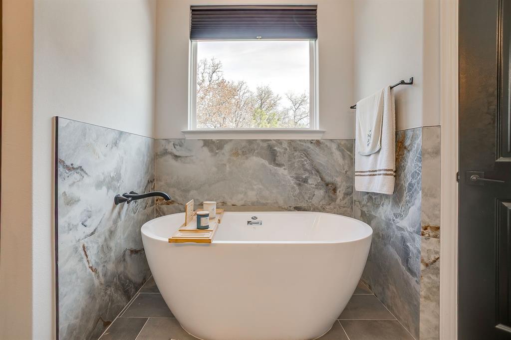1040 Rose Court Nemo, TX 76070 - Photo 23 of 40 a white bath tub sitting in a bathroom next to a window