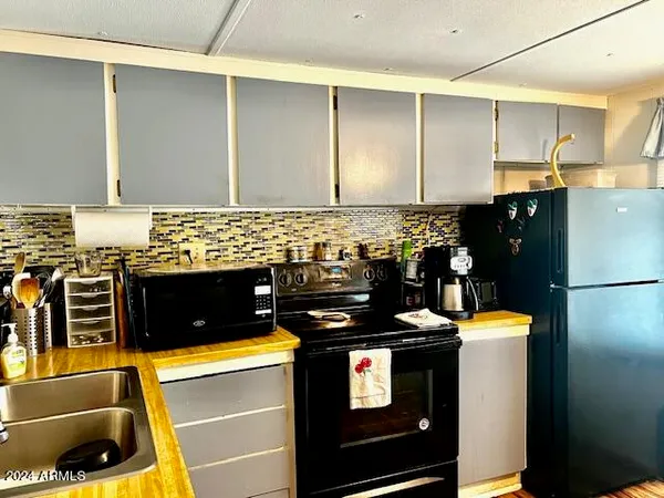 a kitchen with sink refrigerator dining table and chairs