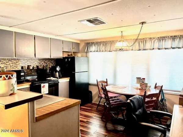 a kitchen with stainless steel appliances kitchen island granite countertop a table chairs and a refrigerator