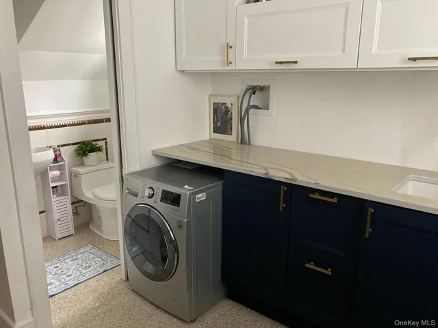 a utility room with sink dryer and washer