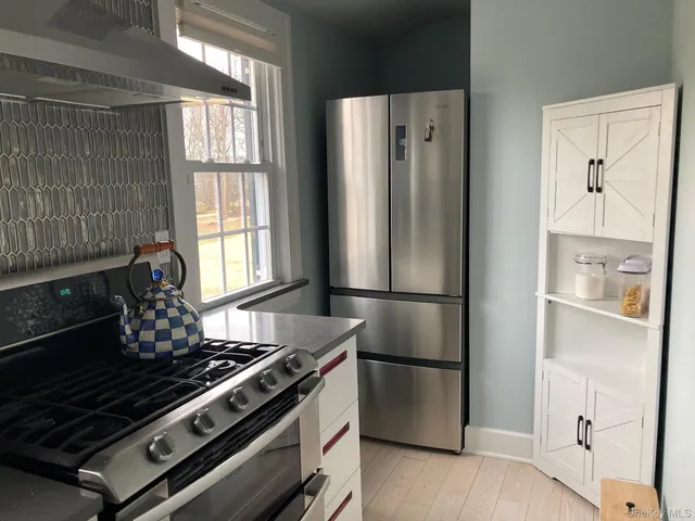 a kitchen with stainless steel appliances a refrigerator a stove and a window