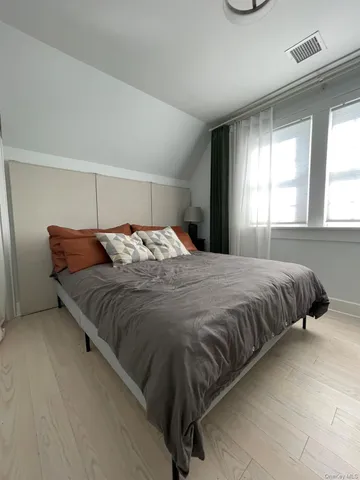a large bed sitting in a bedroom next to a window