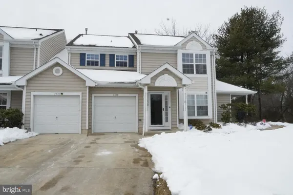 a front view of a house with a yard covered in snow