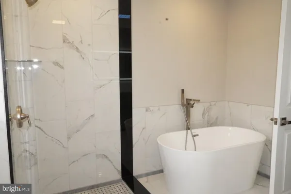 a spacious bathroom with a double vanity sink a mirror and a bathtub