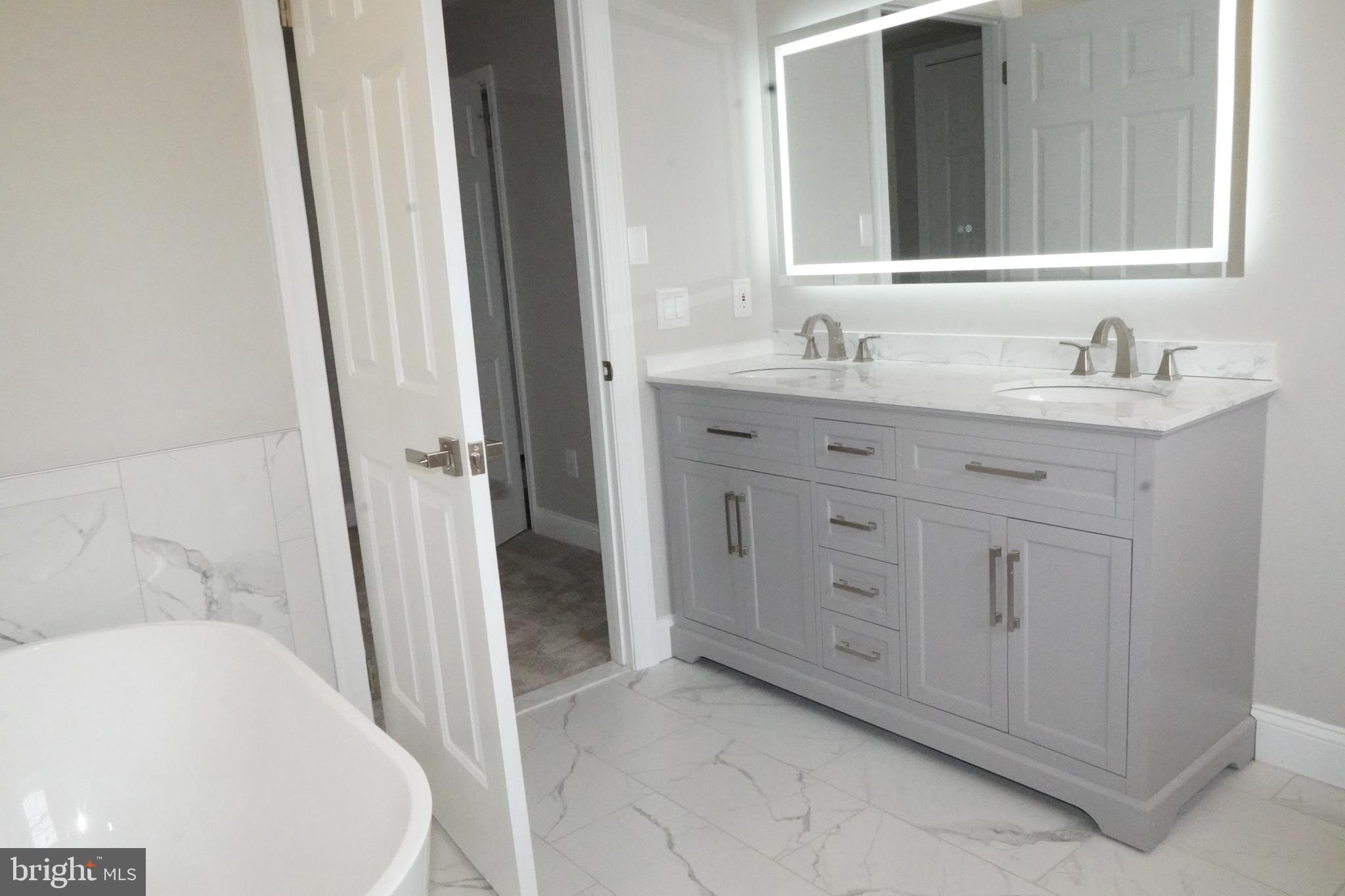 7308 B Normandy Drive Mount Laurel, NJ 08054 - Photo 19 of 23 a spacious bathroom with a double vanity sink a mirror and a bathtub