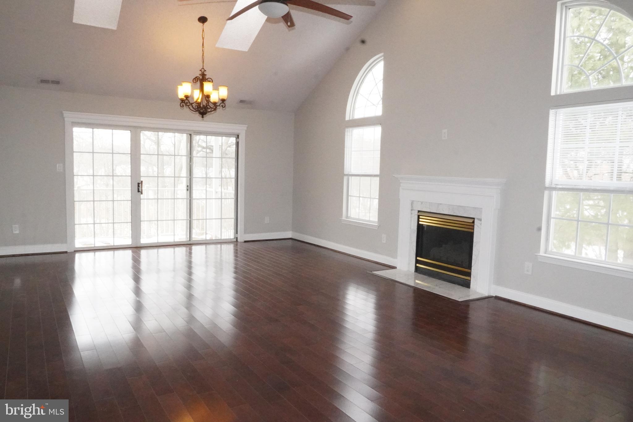 7308 B Normandy Drive Mount Laurel, NJ 08054 - Photo 2 of 23 an empty room with wooden floor fireplace and windows