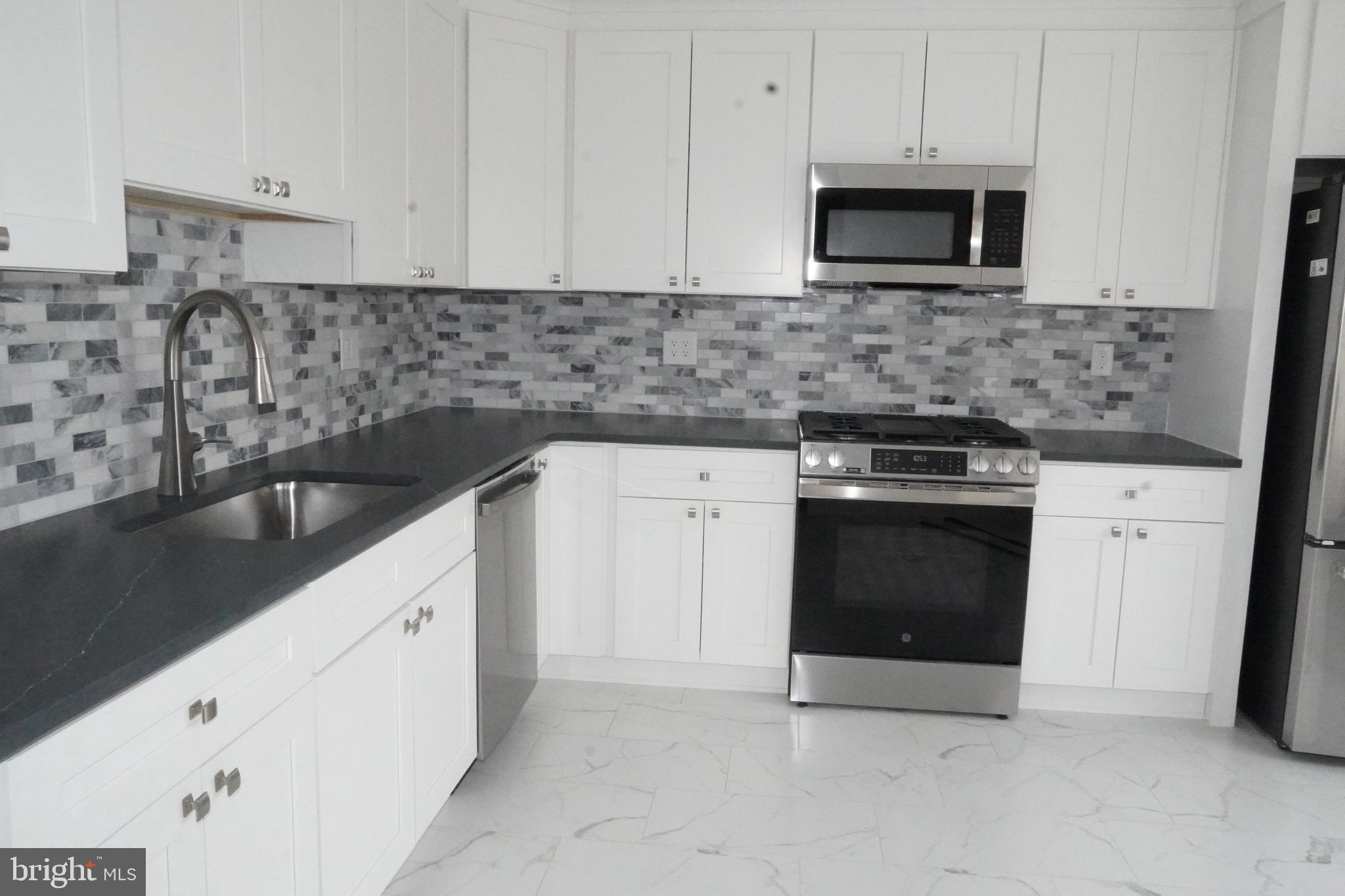 7308 B Normandy Drive Mount Laurel, NJ 08054 - Photo 5 of 23 a kitchen with granite countertop white cabinets and stainless steel appliances