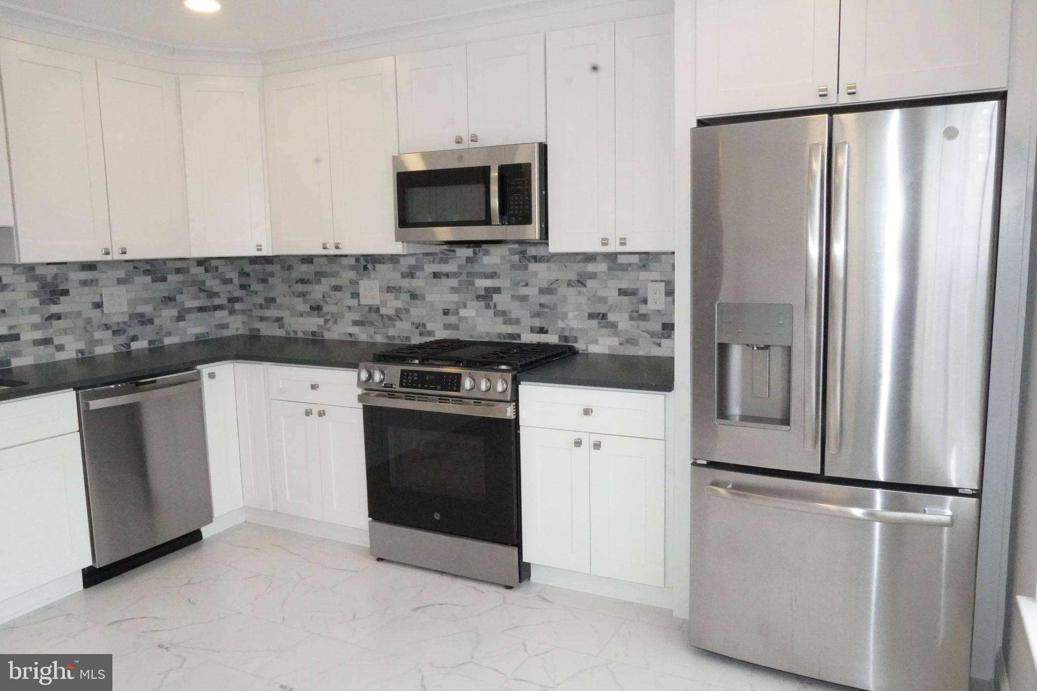 7308 B Normandy Drive Mount Laurel, NJ 08054 - Photo 6 of 23 a kitchen with stainless steel appliances a refrigerator stove and microwave