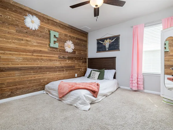 a bedroom with a bed and a wall painting