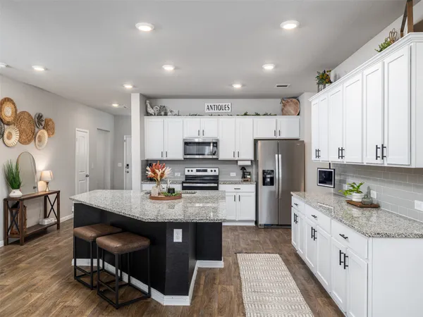 a kitchen with refrigerator cabinets and wooden floor
