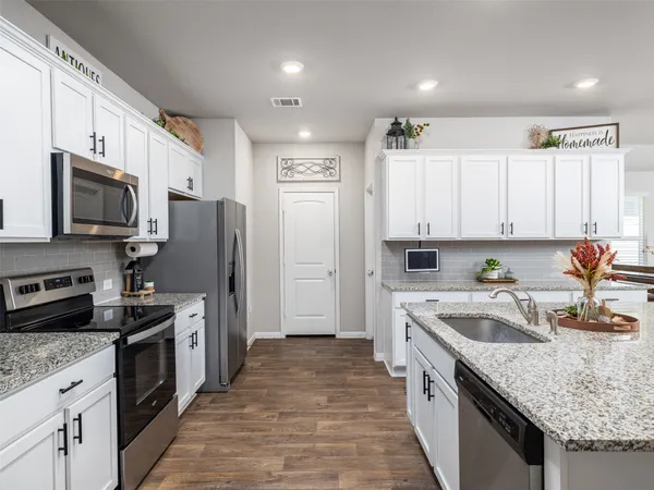 a kitchen with a sink stove top oven and refrigerator
