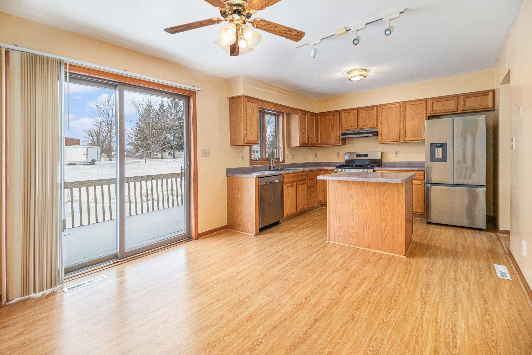 9082 Dallas Place Crown Point, IN 46307 - Photo 5 of 20 a kitchen with stainless steel appliances granite countertop a refrigerator a stove top oven a sink with wooden floors and large cabinets