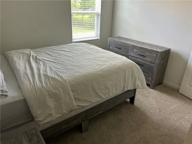 a bed sitting in a bedroom next to a window