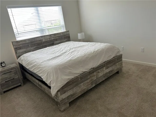 a bed sitting in a bedroom next to a window