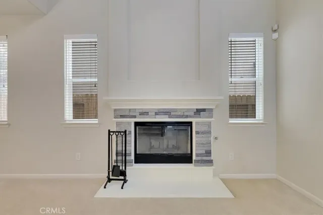 a living room with a fireplace and windows