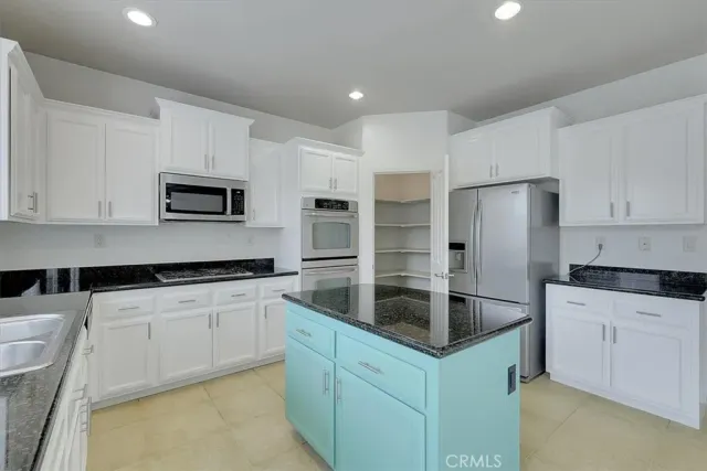a kitchen with granite countertop a cabinets and steel stainless steel appliances with cabinets