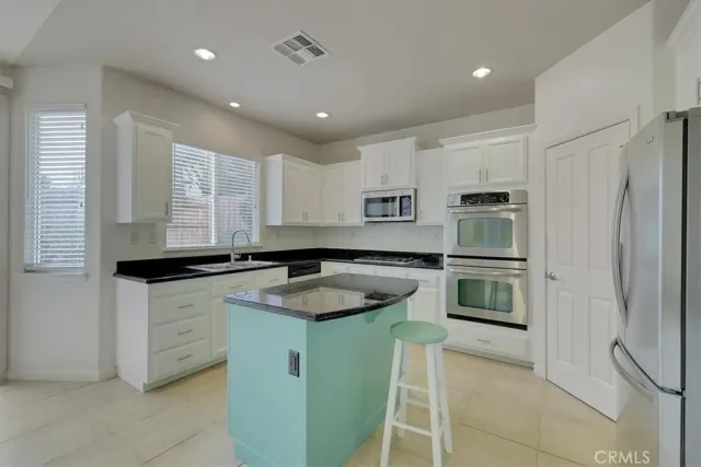 a kitchen with granite countertop a sink stainless steel appliances and cabinets