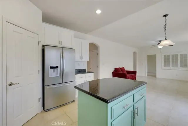 a kitchen that has a kitchen island white cabinets and stainless steel appliances