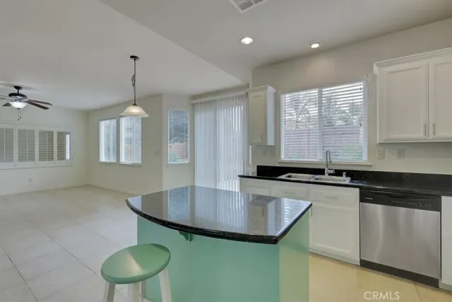 a kitchen with stainless steel appliances granite countertop a sink a window and chairs