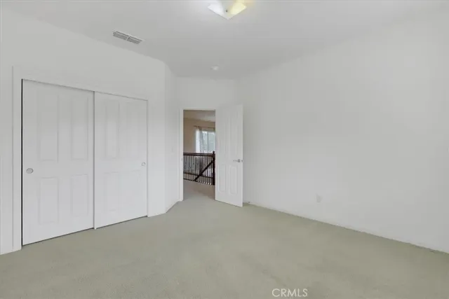 an empty room with fan and windows