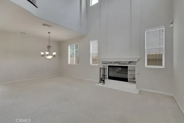 an empty room with windows and fireplace