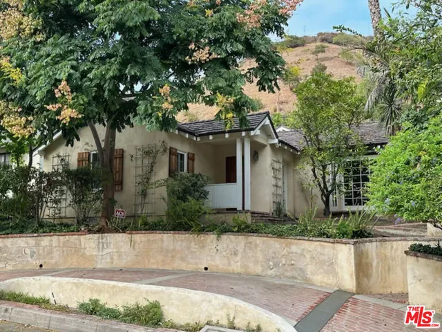 a front view of a house with a yard and trees