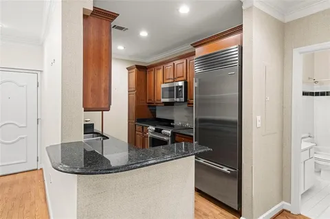 a kitchen with stainless steel appliances granite countertop a stove a sink and a refrigerator
