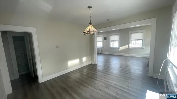 a hallway with wooden floor windows and stairs