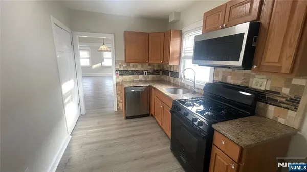 a kitchen with stainless steel appliances granite countertop a stove a sink and a refrigerator