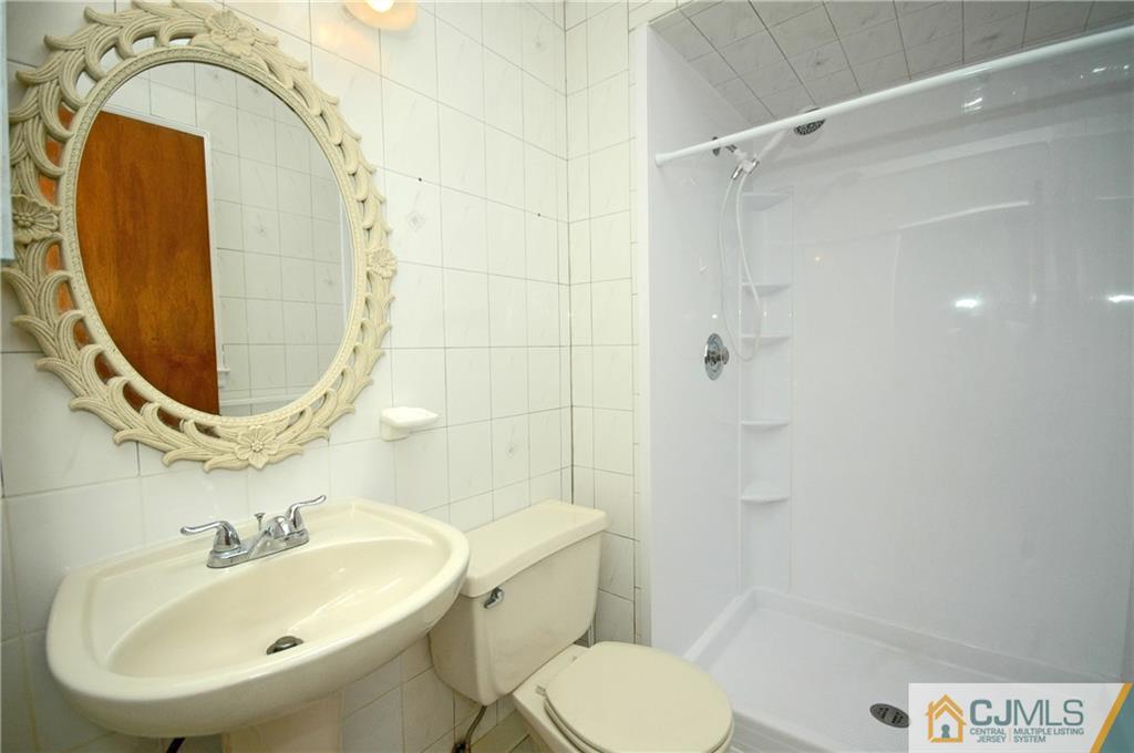 43 Brookside Road Edison, NJ 08817 - Photo 11 of 21 a bathroom with a sink a toilet and a mirror