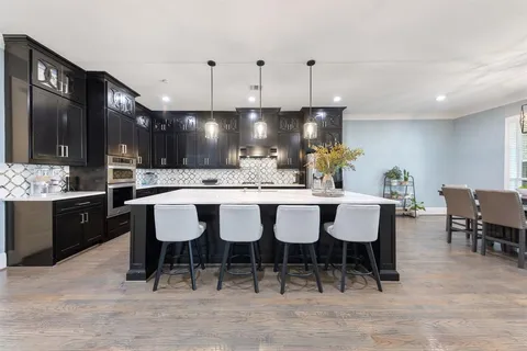 a kitchen with stainless steel appliances granite countertop a sink a stove and refrigerator