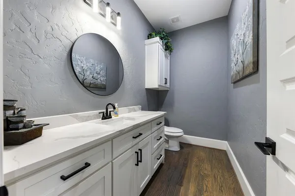 a bathroom with a granite countertop sink and a mirror