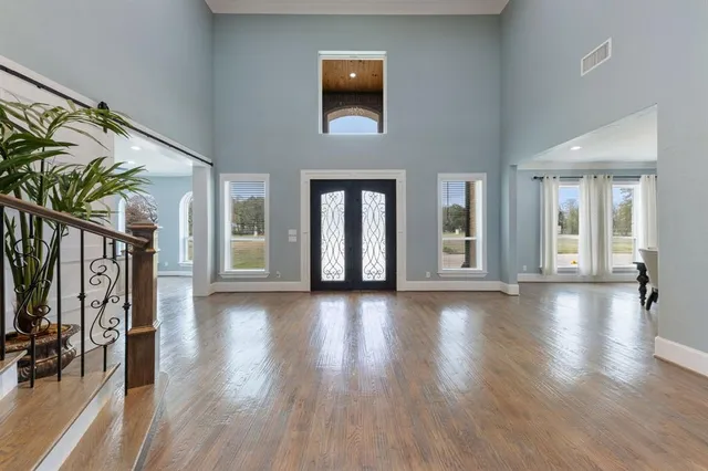 a view of a hallway with wooden floor and windows