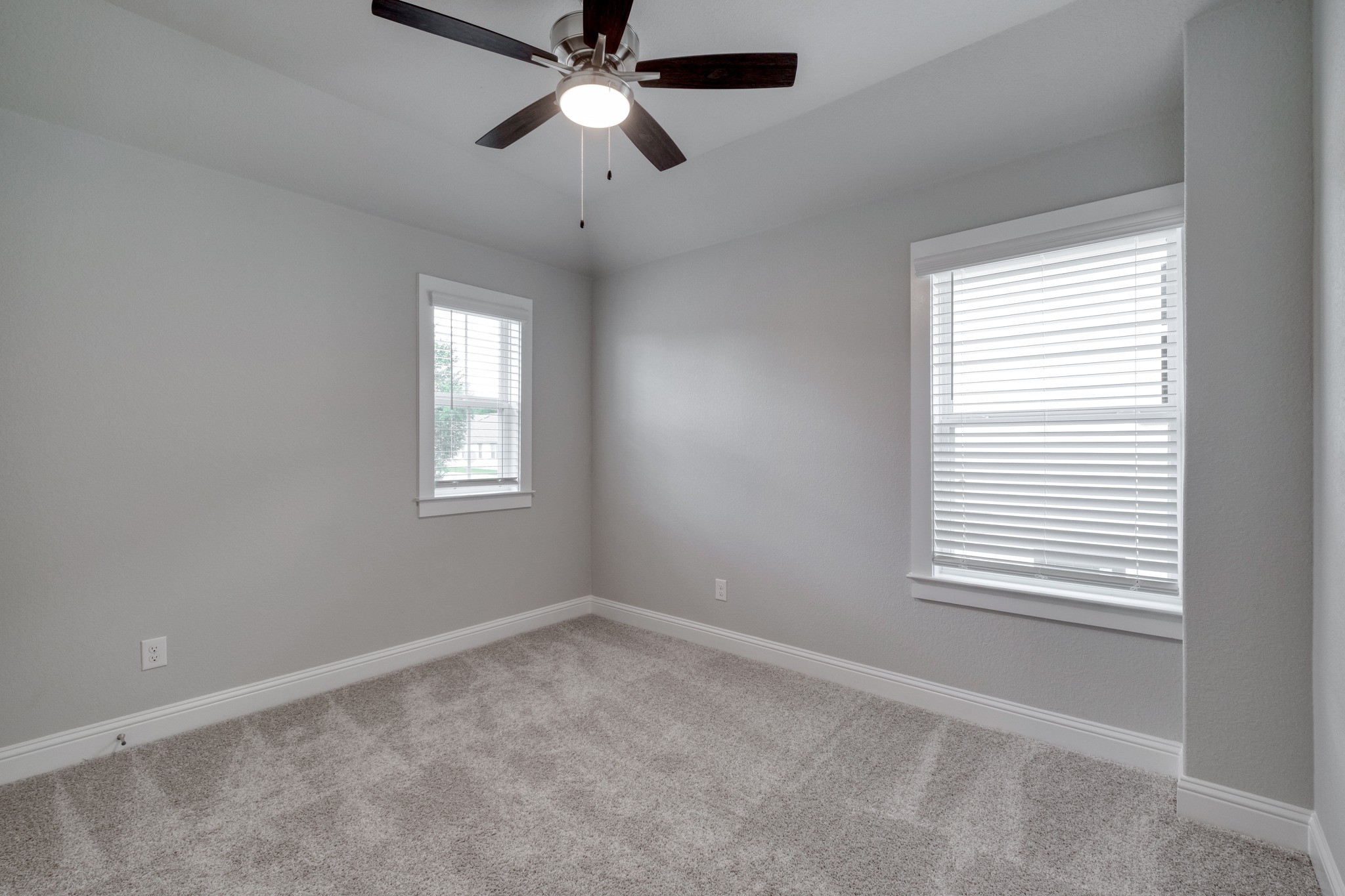 2605 Sam Bass Road, Unit 44 Round Rock, TX 78681 - Photo 20 of 26 A well-lit bedroom features plush carpeting and two sun-filtering windows.