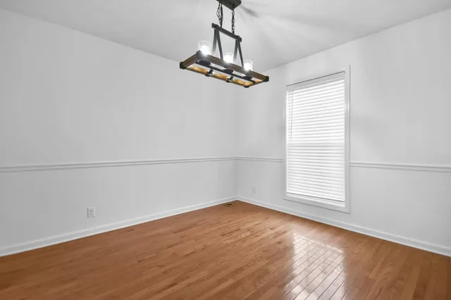 a view of a room with wooden floor and windows