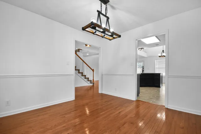 a view of a hallway with wooden floor and staircase