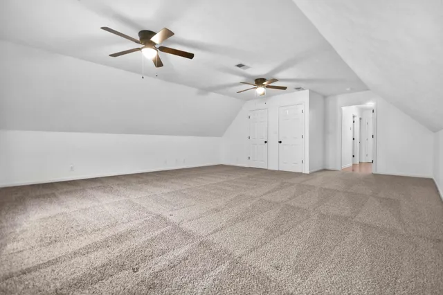 an empty room with fan and windows