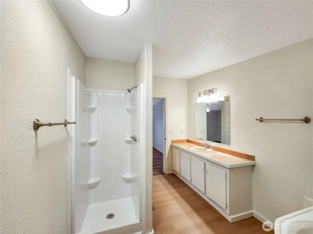 a bathroom with a double vanity sink a toilet and shower