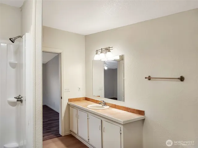 a bathroom with a granite countertop sink and mirror