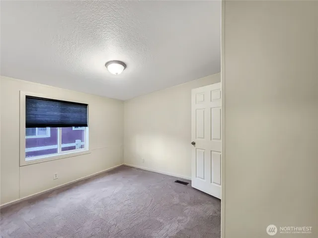 a view of room with window and wooden floor