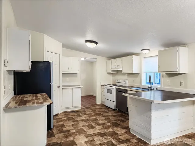 a kitchen with a stove a sink and a refrigerator
