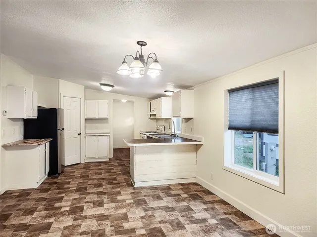 a large white kitchen with a stove a sink and a refrigerator