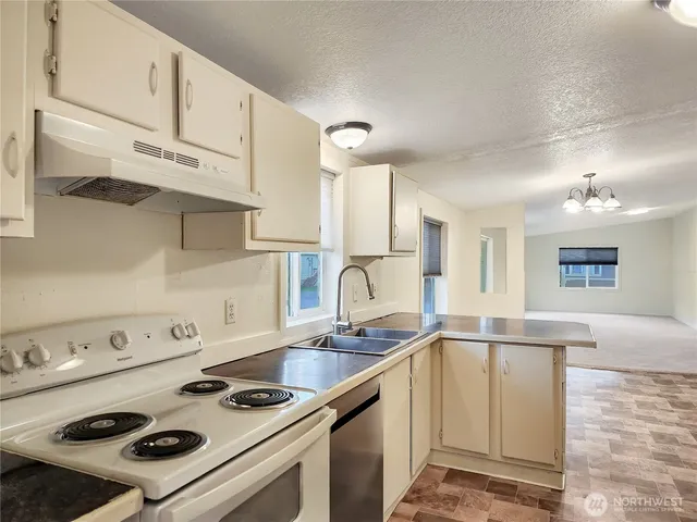 a kitchen with kitchen island a sink stove and cabinets