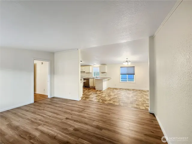 a view of empty room with wooden floor
