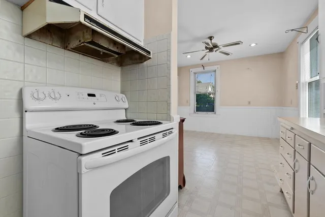 a stove top oven sitting inside of a kitchen