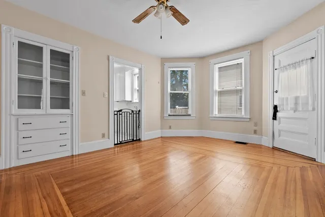 an empty room with cabinet and windows
